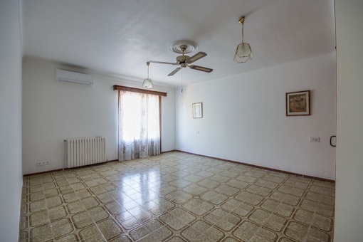 Kleines Schlafzimmer mit hohen Fenstern und Heizung