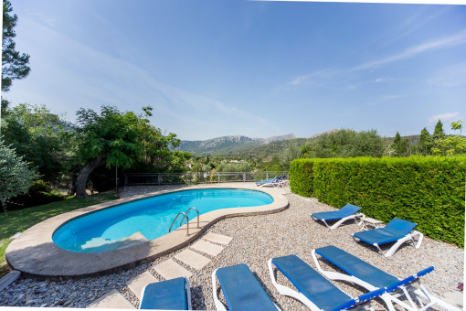 Der Swimmingpool ist von einer Terrasse mit Liegestühlen umgeben