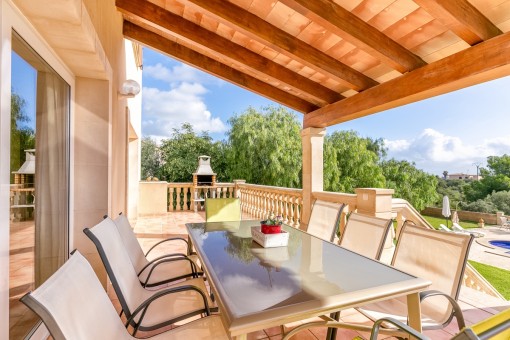 Überdachte Terrasse mit Sitzgelegenheit und Grill