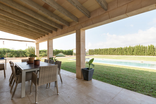 Überdachte Terrasse mit Poolblick