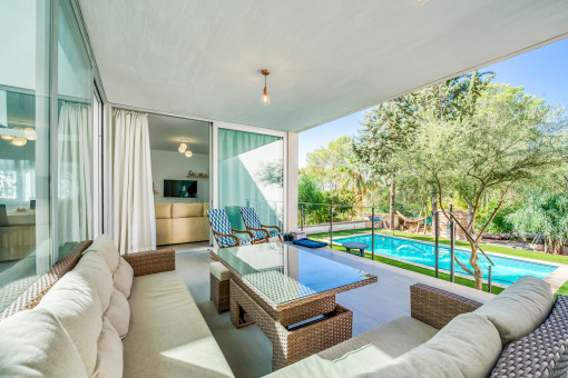 Überdachte Loungeterrasse mit Poolblick
