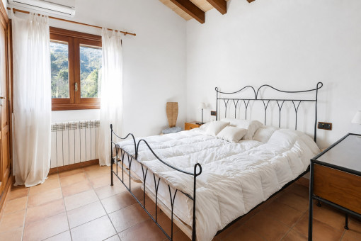 Helles Schlafzimmer mit schmiedeeisernem Bettgestell