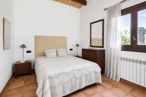 Schlichtes Schlafzimmer mit Holzmöbeln und Fenster