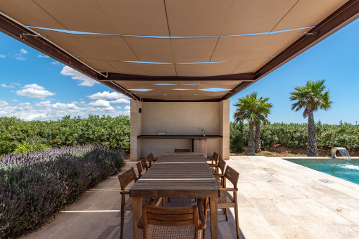 Poolterrasse mit Pergola und vorbereitetem Bereich für eine Außenküche