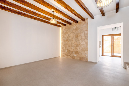 Wohnbereich mit Natursteinwand und Holzbalkendecke