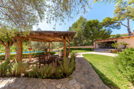 Garten mit überdachter Terrasse und Poolblick