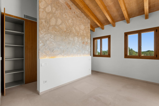 Hauptschlafzimmer mit Natursteinwand und Bad en suite