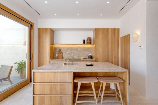 Helle Designküche mit Naturmaterialien und direktem Zugang zum Patio