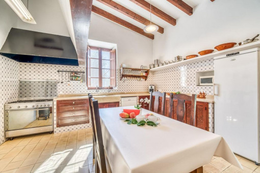 Großzügige Küche im mallorquinischen Stil – mit viel Stauraum, Essbereich und Zugang zur Terrasse