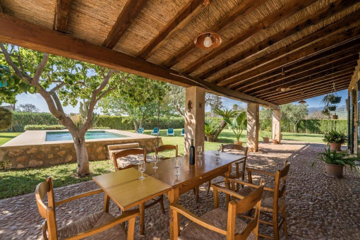 Überdachte Veranda mit Esstisch im Freien