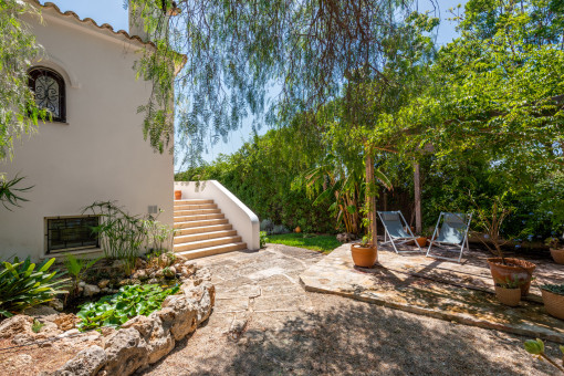 Teich mit Seerosen und gemütlicher Sitzecke im Garten