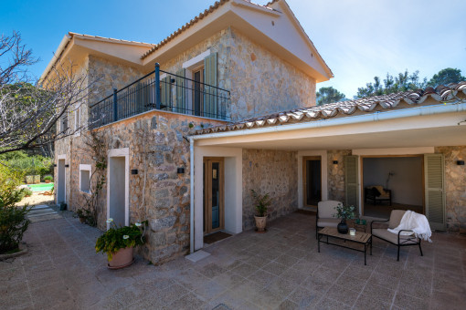 Seitenansicht der Natursteinfassade und der Eingangsveranda