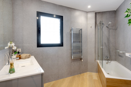 Badezimmer mit Duschwanne und Handtuchwärmer