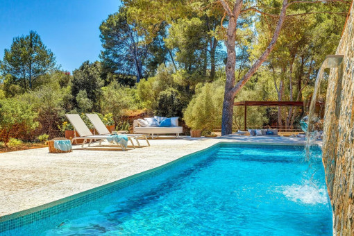 Privater Pool mit Wasserfall, umgeben von mediterraner Natur