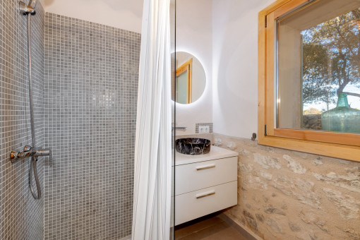 Bad mit Mosaikdusche und stilvollem Naturstein