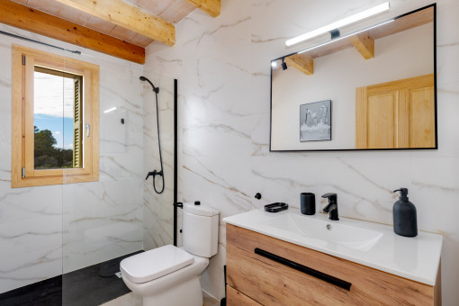 Badezimmer mit stilvollem Naturstein und bodenebener Dusche