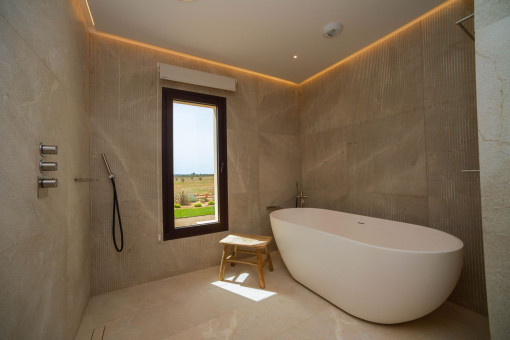 Luxuriöses Masterbad mit Naturstein und stilvoller Badewanne