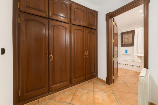 Flur mit Holzschrank und Badezimmerblick