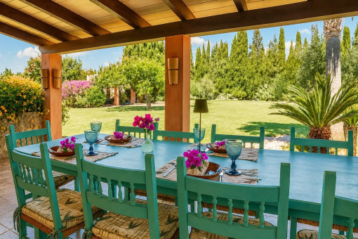 Überdachte Terrasse mit Esstisch und Gartenausblick
