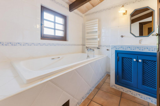 Badezimmer mit Badewanne und blauem Schrank