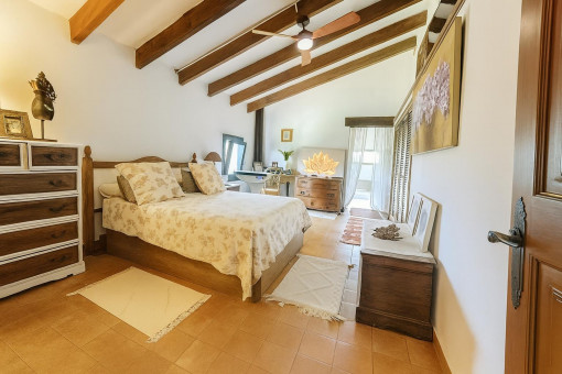 Helles Schlafzimmer mit sichtbaren Deckenbalken