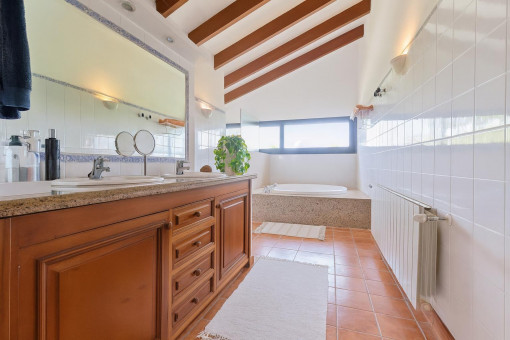 Helles Badezimmer mit Badewanne und Holzschrank