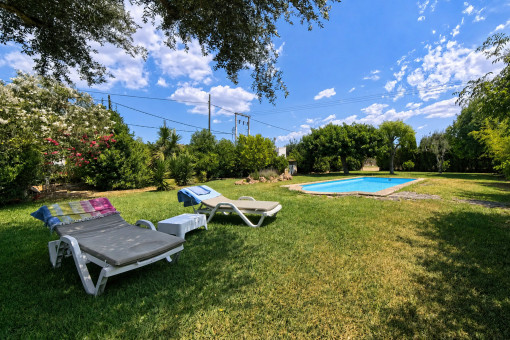 Swimmingpool mit Sonnenliegen im gepflegten Garten