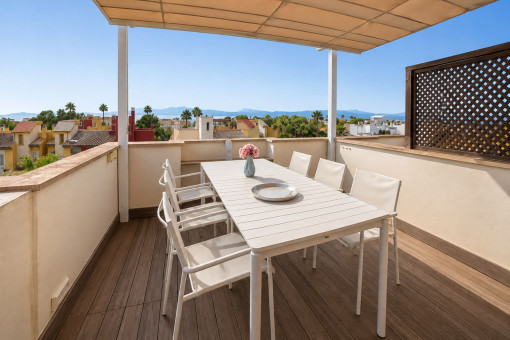 Überdachte Dachterrasse mit Tisch und Stühlen