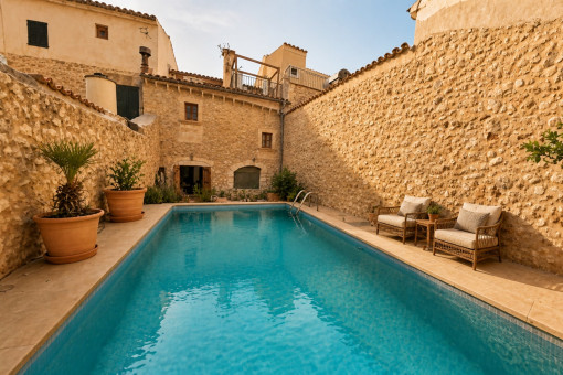 Privater Pool mit rustikaler Steinmauer und Sitzgelegenheiten
