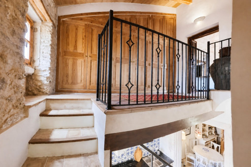 Steintreppe mit Holzschränken und Geländer