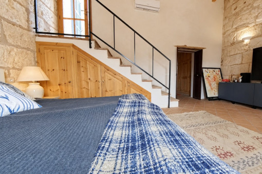 Gemütliches Schlafzimmer mit Treppe und Fernseher