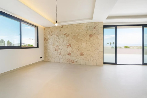 Offener Wohn- und Essbereich mit Natursteinwand
