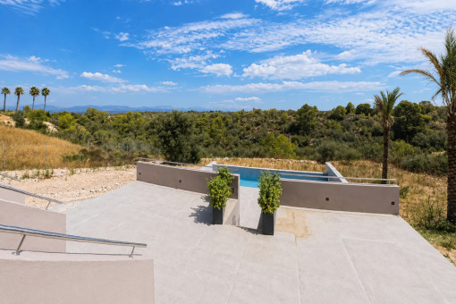 Sonnige Poolterrasse mit offenem Blick ins Grüne